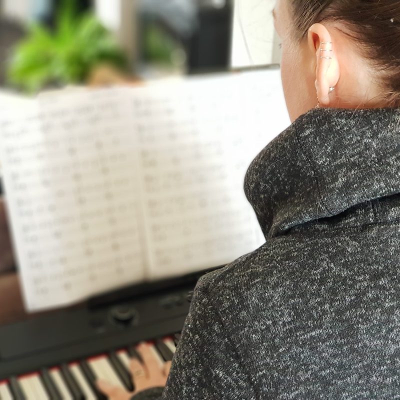 photo of Beth Nixon singing teacher playing piano from behind